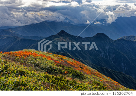Cloud-filled mountain range at dusk as seen from Mt. Monnai in the Iide mountain range 125202704
