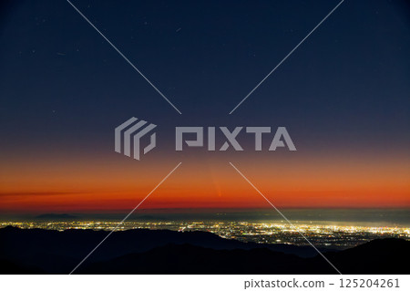 The city lights of the Niigata Plain, Mount Shikin, and Comet ATLAS seen from Mount Gonishi in the Iide Mountain Range 125204261