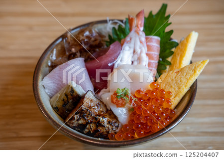 Kaisen Don, a Japanese rice bowl dish of seafood. Including raw fish such as Hotate, Salmon, Saba, Engawa, Foie gras, Ikura. Kaisen Don, a Japanese rice bowl dish of seafood. Including raw fish such as Hotate, Salmon, Saba, Engawa, Foie gras, Ikura. 125204407