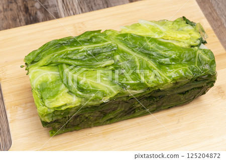 Remove the solidified vegetable terrine from the mold and cut it with a knife. 125204872