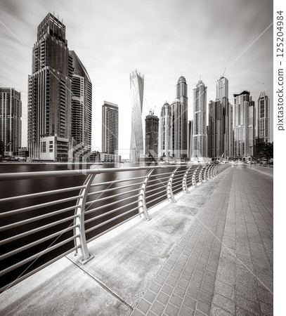 Skyscrapers and bridge over water, black and white style, city background, Dubai Marina bay UAE 125204984