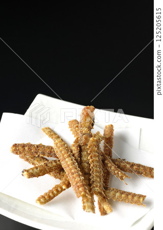 Eel bone rice crackers photographed against a black background Eel bone rice crackers photographed against a black background 125205615