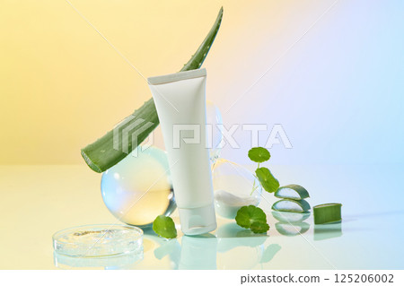 A long, pointed aloe vera plant with small spines running along its edges sits on a glass globe. In front are unlabeled cosmetic tubes and pennywort and aloe vera segments. Laboratory concept. A long, pointed aloe vera plant with small spines running along its edges sits on a glass globe. In front are unlabeled cosmetic tubes and pennywort and aloe vera segments. Laboratory concept. 125206002