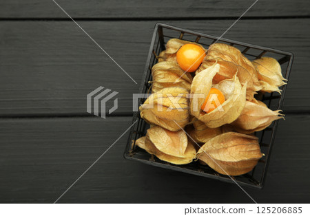 Physalis peruviana fruit on black wooden background. Physalis peruviana fruit on black wooden background. 125206885