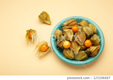 Physalis peruviana fruit on blue plate on beige background. 125206887
