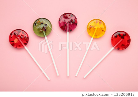 Colorful sweet lollipops with berries on pink background. Colorful sweet lollipops with berries on pink background. 125206912