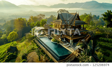 Stunning aerial view of a luxurious wooden house with a pool, surrounded by lush greenery and majestic mountains. Stunning aerial view of a luxurious wooden house with a pool, surrounded by lush greenery and majestic mountains. 125206974
