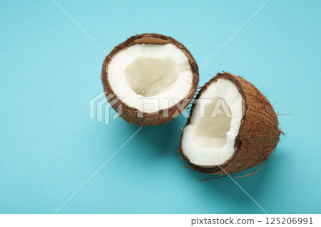 Coconut with half on blue background. Space for text 125206991