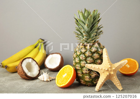 Tropical fruits. Pineapple, coconut, orange and banana on grey background Tropical fruits. Pineapple, coconut, orange and banana on grey background 125207016