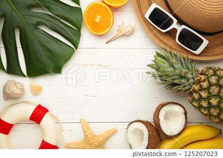 Tropical leaves and fruits, hat, summer concept on white wooden background. Copy space Tropical leaves and fruits, hat, summer concept on white wooden background. Copy space 125207023