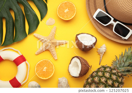 Tropical leaves and fruits, hat, summer concept on yellow background. Copy space 125207025