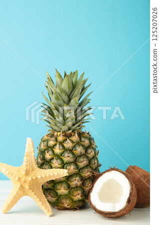 Pineapple with coconut on blue background. Tropical fruit. Vertical photo 125207026