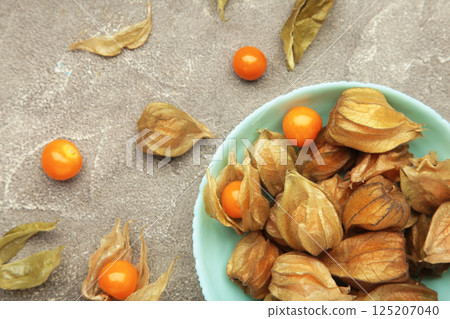Physalis peruviana fruit on mint plate on grey background. 125207040