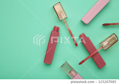 Beautiful lip glosses on a mint background Beautiful lip glosses on a mint background 125207085