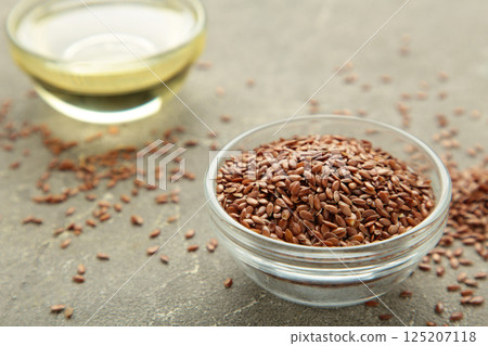 Flax seeds and oil in bottle on grey background 125207118