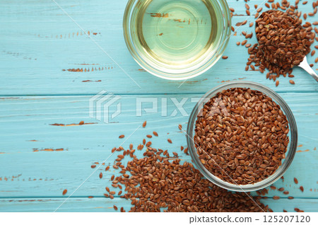 Flax seeds and oil in bottle on blue wooden background 125207120