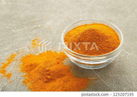 Turmeric powder in bowl on grey background. 125207195