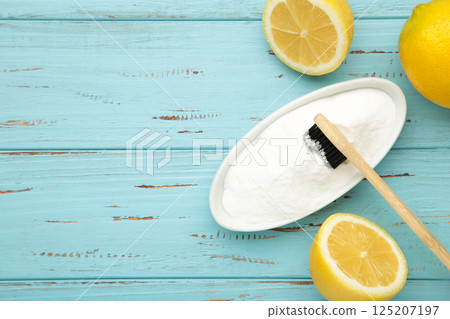 Toothbrush with lemon and baking soda on blue wooden background. Space for text 125207197