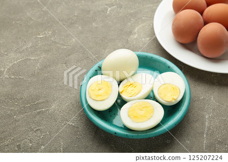 Boiled eggs in white ceramic plate on grey background. 125207224