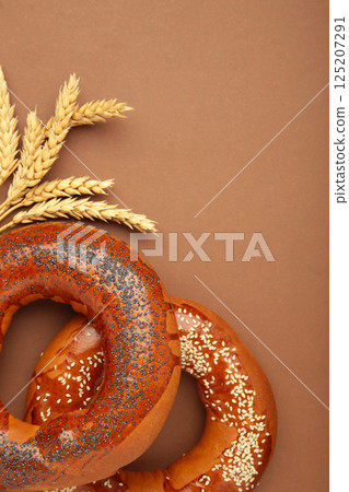 Fresh bread bagels with poppy seed on brown background. 125207291