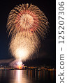 A fireworks display that lights up the mountains and townscape on a summer night 125207306