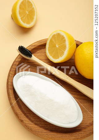 Toothbrush with lemon and baking soda on beige background. Vertical photo 125207352