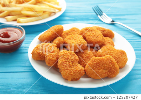 Homemade chicken nuggets and french fries with ketchup on blue wooden background. 125207427