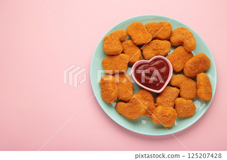 Chicken nuggets with ketchup on plate on pink background. 125207428