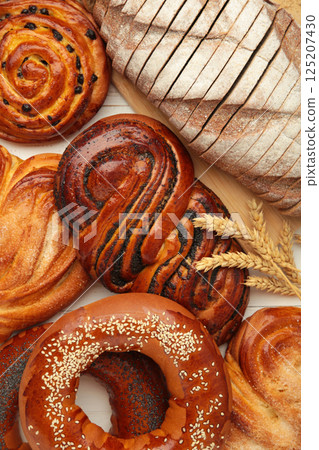 Bakery - various kinds of breadstuff. Bread rolls, bagel, sweet bun. Vertical photo 125207430