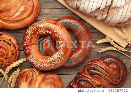 Bakery - various kinds of breadstuff. Bread rolls, bagel, sweet bun on grey background. 125207432