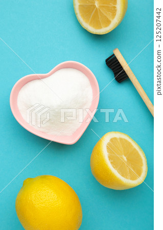 Toothbrush with lemon and baking soda on blue background. Vertical photo Toothbrush with lemon and baking soda on blue background. Vertical photo 125207442