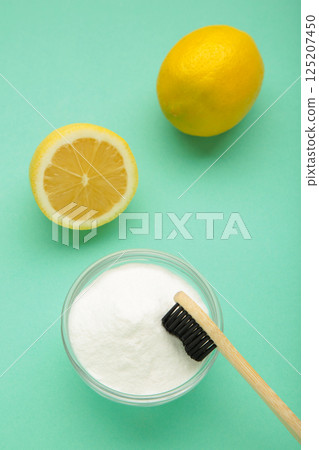 Toothbrush with lemon and baking soda on mint background. Vertical photo 125207450