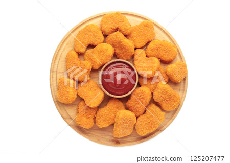 Chicken nuggets with ketchup on cutting board isolated on white background. Chicken nuggets with ketchup on cutting board isolated on white background. 125207477