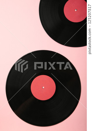 Gramophone vinyl records on pink background. Vertical photo 125207817