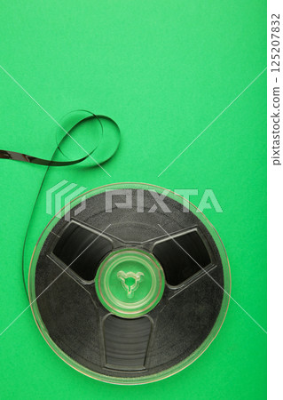 Film reel on green background. Vertical photo 125207832