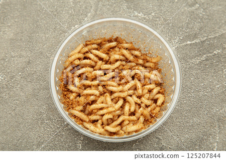 Plastic container, box with live bait for fishing - maggots, on grey background 125207844