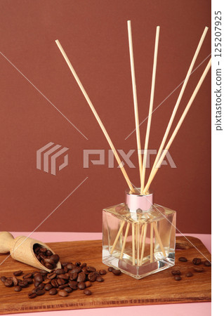 Reed diffuser and coffee beans on brown background. Vertical photo 125207925