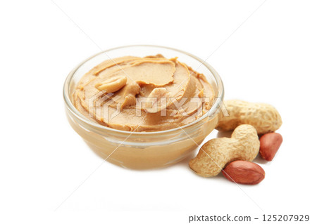 Bowl of peanut butter and peanuts isolated on white background. Creamy peanut pasta in small bowl. Bowl of peanut butter and peanuts isolated on white background. Creamy peanut pasta in small bowl. 125207929