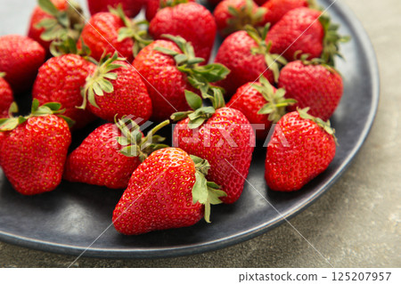 Top of view fresh strawberry in dark plate on grey concrete background. Top of view fresh strawberry in dark plate on grey concrete background. 125207957