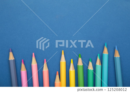 Pastel color pencils on blue background. Space for text Pastel color pencils on blue background. Space for text 125208012