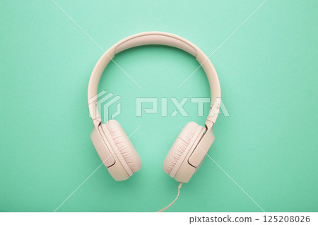 Pink modern headphones on a mint background 125208026