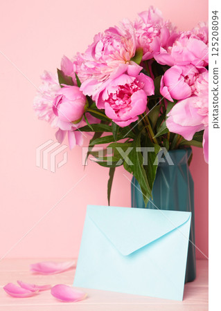 Envelope with pink peony flowers on pink background. Envelope with pink peony flowers on pink background. 125208094