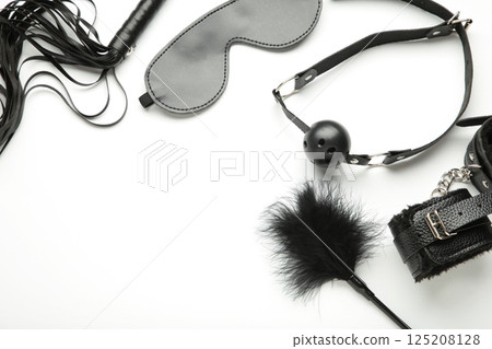 Set of erotic toys for BDSM on white background. The game of sexual slavery with a whip, gag and leather blindfold. Intimate sex games 125208128