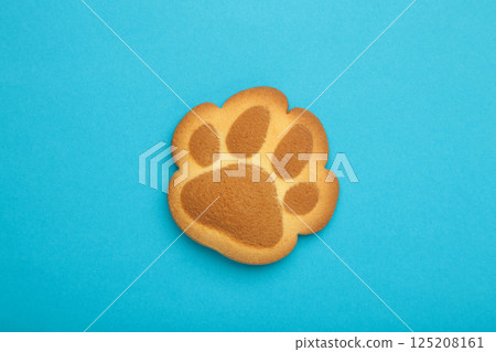 Self made cat paw cookies on blue background. Self made cat paw cookies on blue background. 125208161