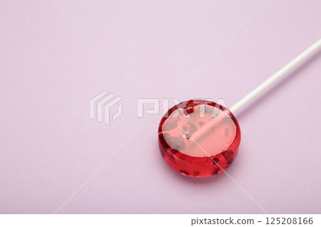Red sweet lollipops with berries on purple background. Space for text Red sweet lollipops with berries on purple background. Space for text 125208166