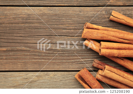 Overhead view of cinnamon sticks dried tree bark spice. Cinnamon on grey wooden background 125208190