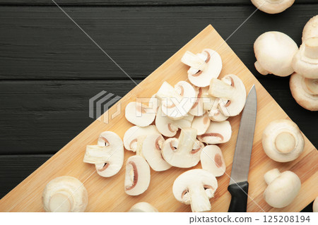 Fresh white champignon mushrooms on cutting board. Space for text Fresh white champignon mushrooms on cutting board. Space for text 125208194