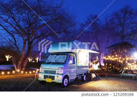 A food truck operating in front of the illuminations on a spring evening 125209166