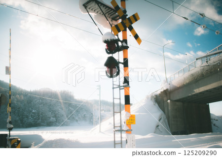 Railroad crossing alarm covered in snow 125209290