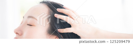 A woman doing hair care and head spa, etc. Close-up of a banner with oil and treatment on her hands 125209479